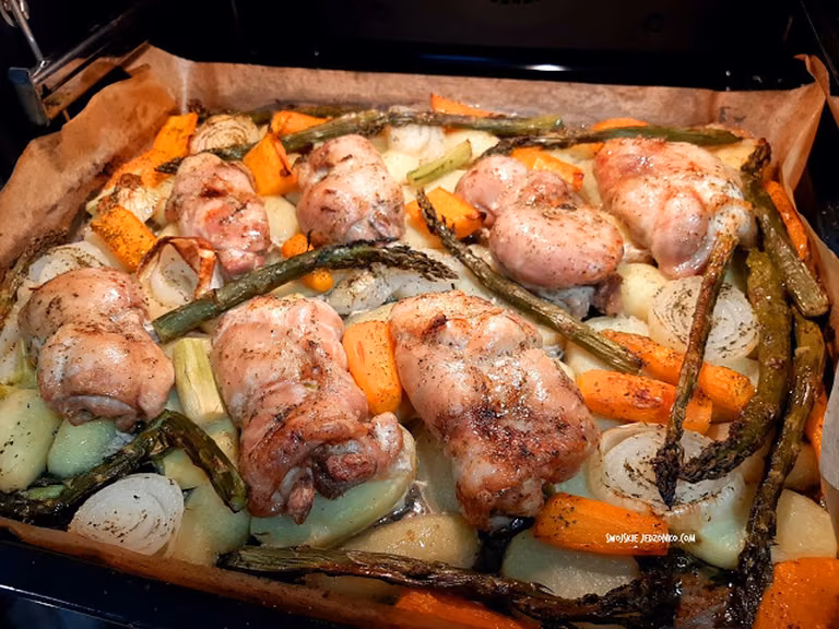 Pieczone udka z masłem czosnkowym i młodymi warzywami