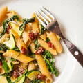 Pełnoziarnisty makaron penne z cukinią, szpinakiem i suszonymi pomidorami