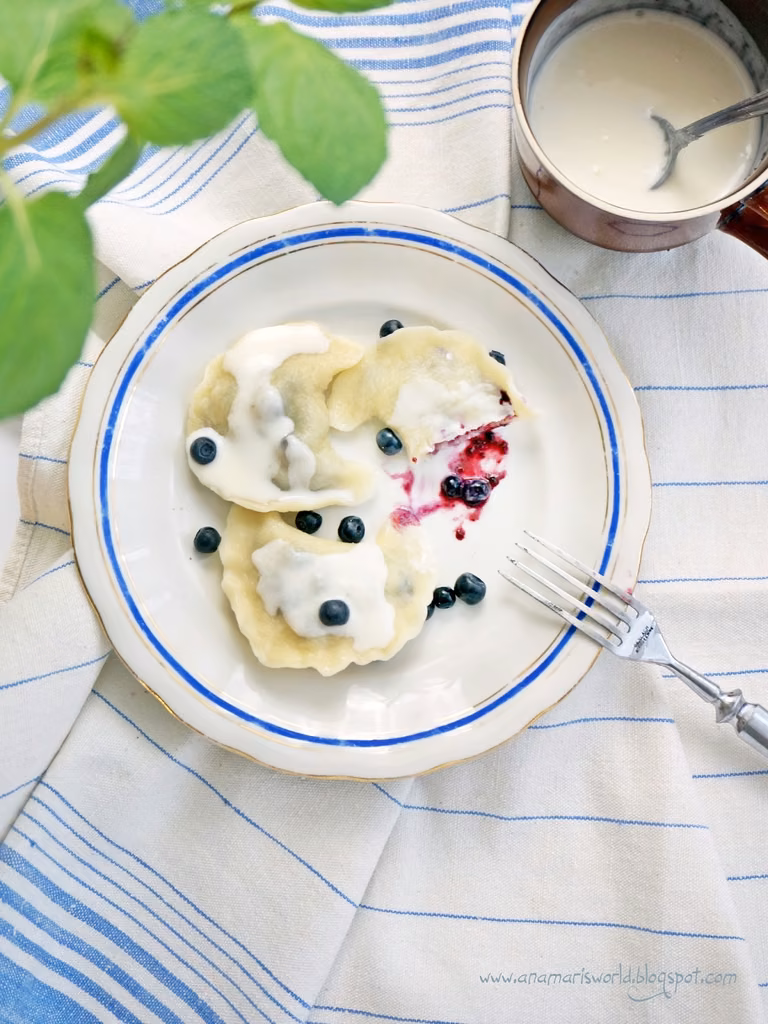 Pierogi z jagodami polane śmietaną
