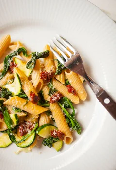 Pełnoziarnisty makaron penne z cukinią, szpinakiem i suszonymi pomidorami