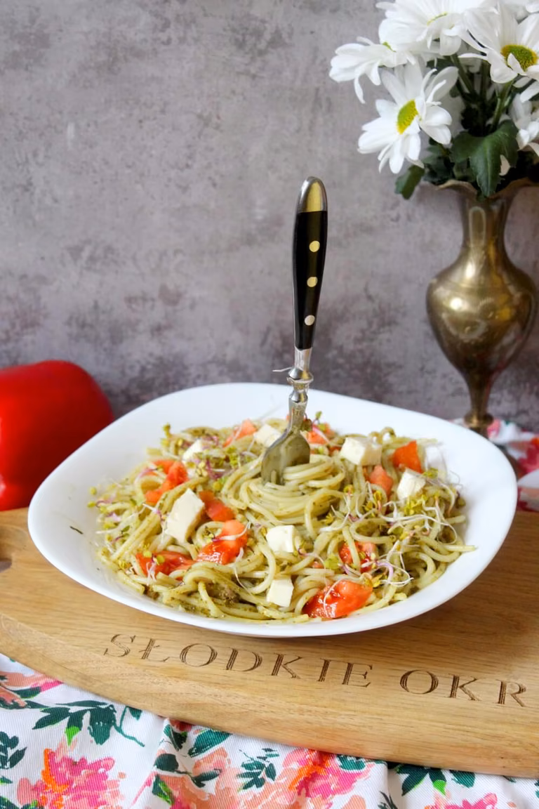 Spaghetti z zielonym pesto, serem i pomidorami