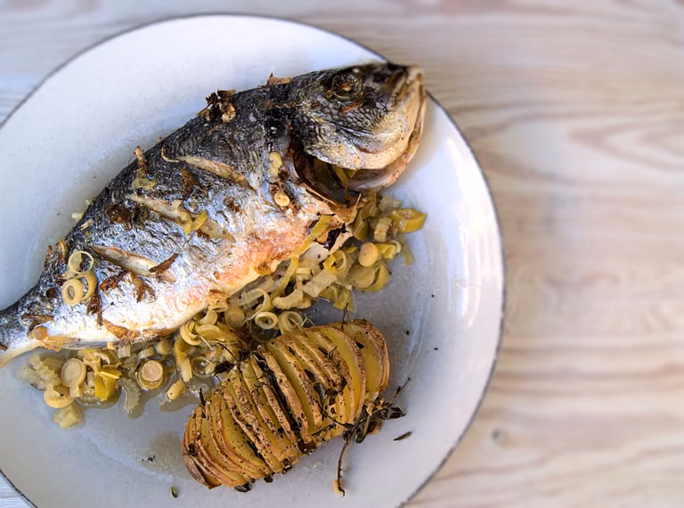 Dorada pieczona w folii podana z ziemniakami hasselback