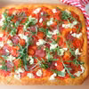 Pizza na grubym cieście z salami, pomidorkami i ricottą