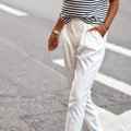 Białe eleganckie spodnie połączone z pasiastą koszulką