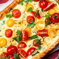 Masę jajeczną wylewam na ciasto francuskie, dorzucam pokruszony ser, pomidorki i rukolę! W 40 minut mam pyszną tarte