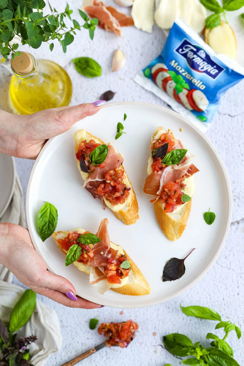 Grzanki z mozzarellą salsą pomidorową i prosciutto