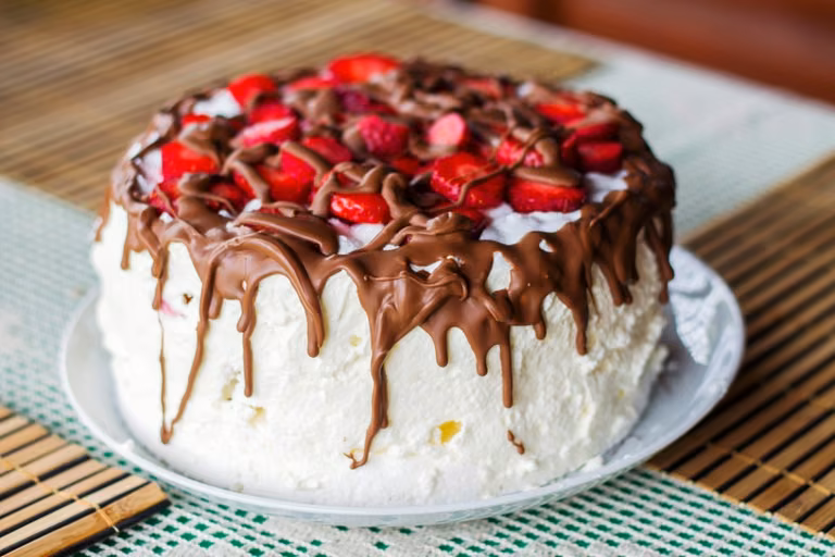 Tort bezowy z bitą śmietaną i truskawkami