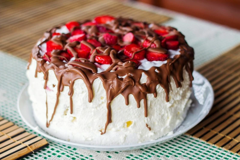 Tort bezowy z bitą śmietaną i truskawkami
