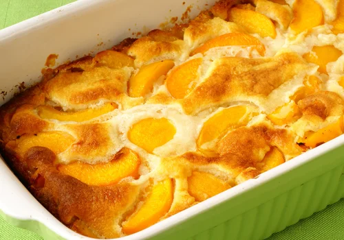 Pokrojone brzoskwinie zalewam tą masą i wkładam do piekarnika! To ciasto to hit na szybki deser