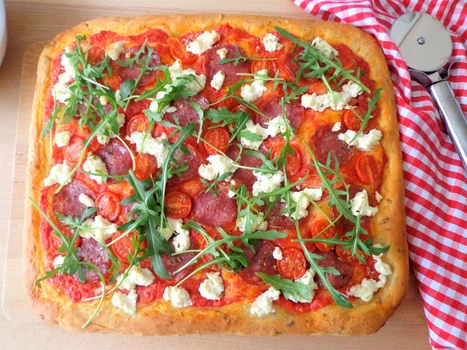 Pizza na grubym cieście z salami, pomidorkami i ricottą