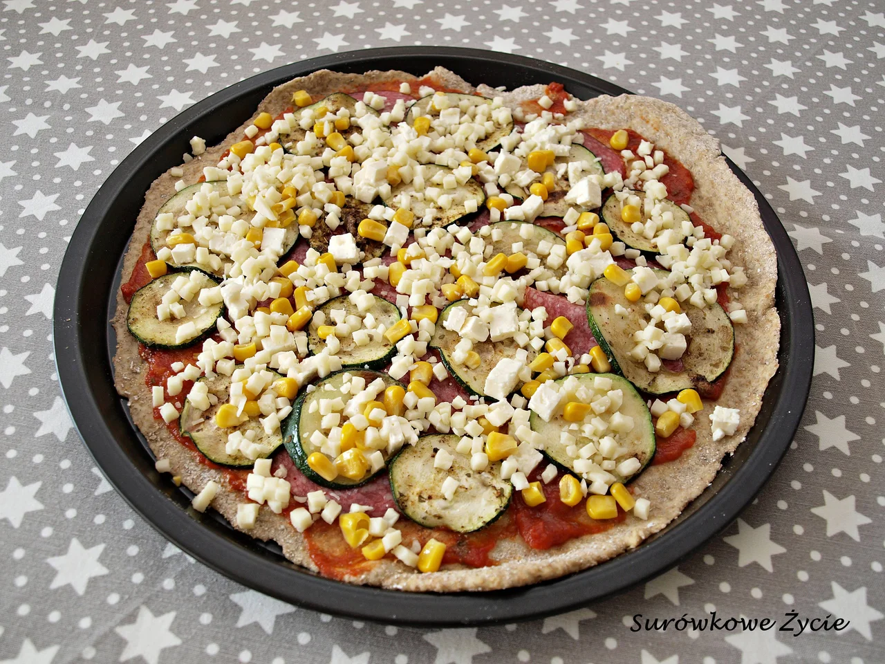 Pizza na razowym cieście z grillowaną cukinią, fetą, salami i oliwkami