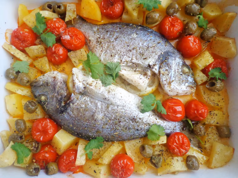 Pieczona dorada z ziemniakami, pomidorkami i oliwkami
