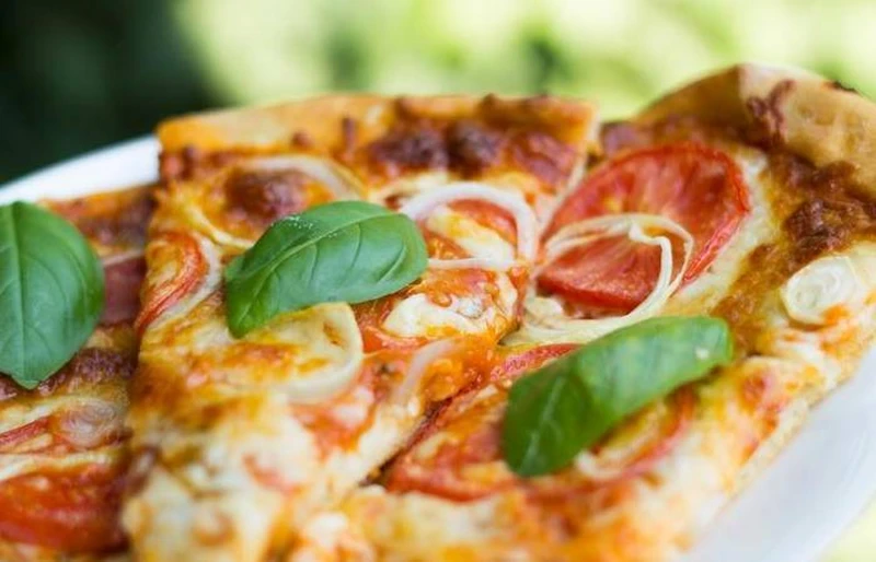 Pizza z pepperoni, pomidorami, cebulą i bazylią