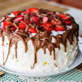 Tort bezowy z bitą śmietaną i truskawkami