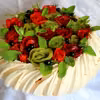 Tort bezowy Pavlova z różami z kiwi i truskawek