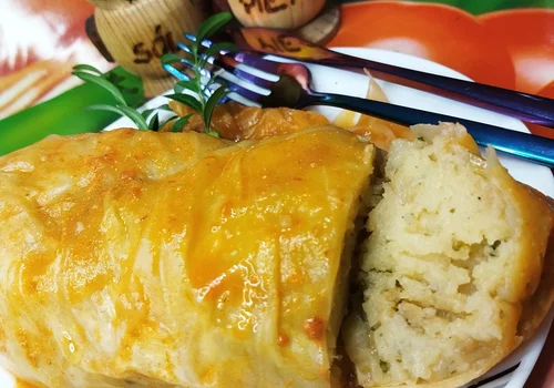 Ziemniaki gotowane z cebulką, zawinięte w liście kapusty stożkowej 'Ala gołąbki w sosie