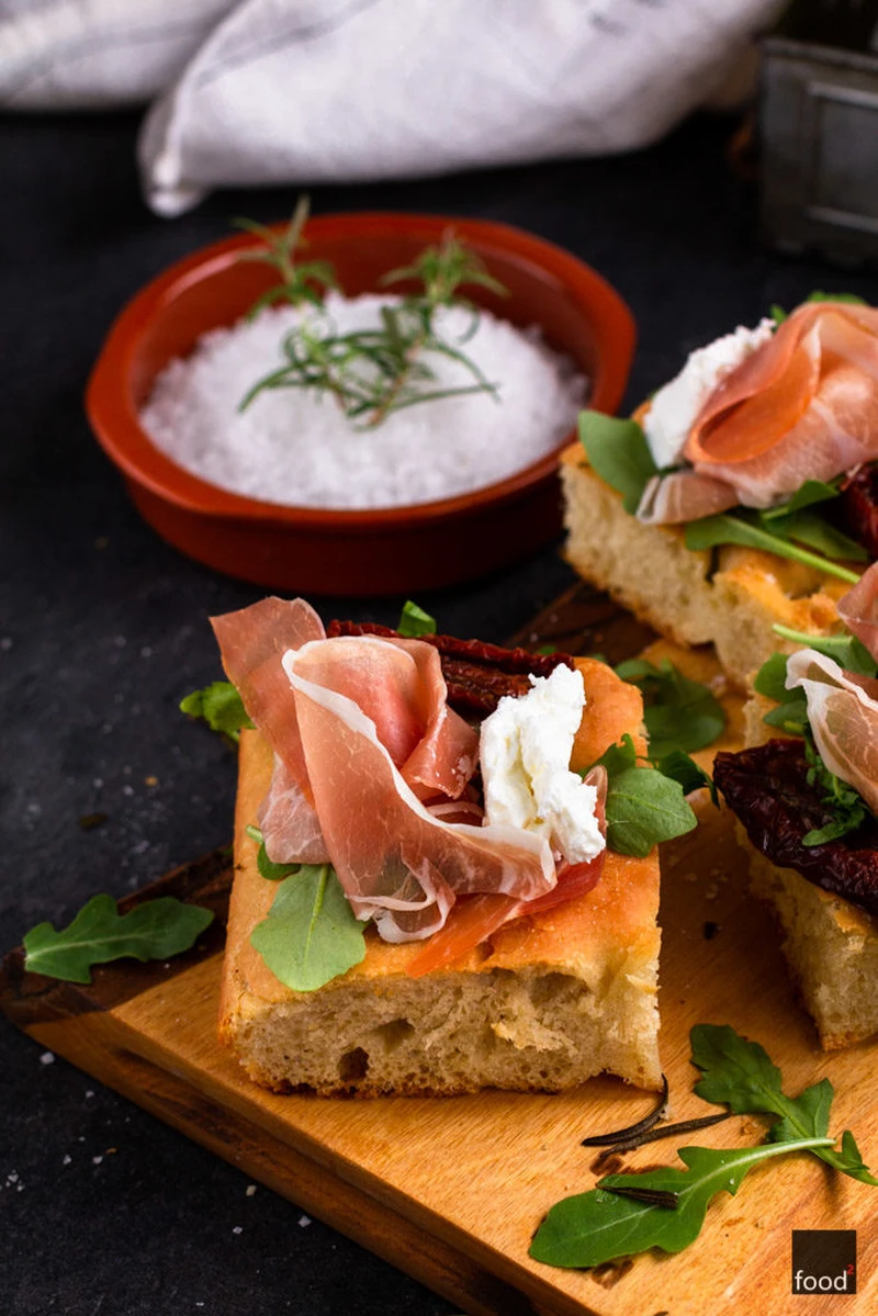 Kanapki z focaccii z szynką parmeńską, ricottą, rukolą i pomidorami suszonymi