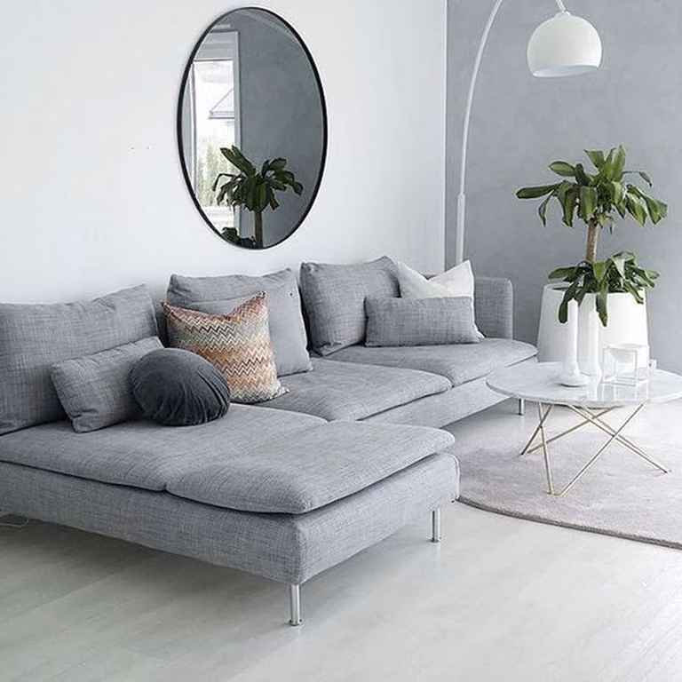 Szara sofa na wąskich nogach