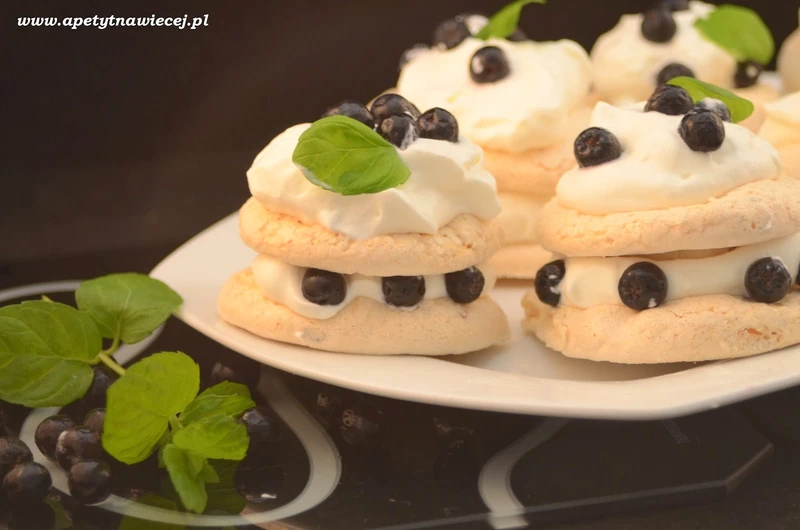 Mini torciki bezowe z bitą śmietaną i mrożonymi owocami aronii