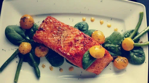 Grillowany łosoś ze świeżym szpinakiem, żółtymi pomidorami i sosem holenderskim