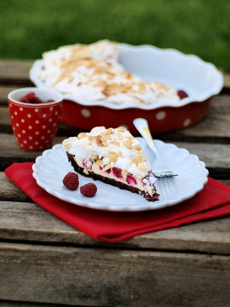 Tarta z nadzieniem serowym, malinami i bezą