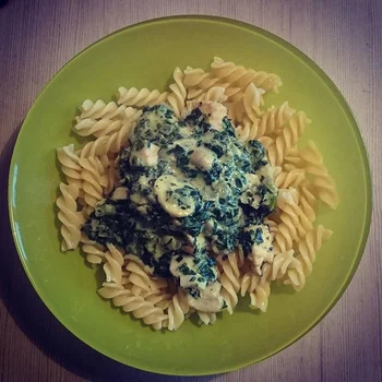 Makaron ze szpinakiem i kawałkami kurczaka w sosie śmietanowym z pieczarkami